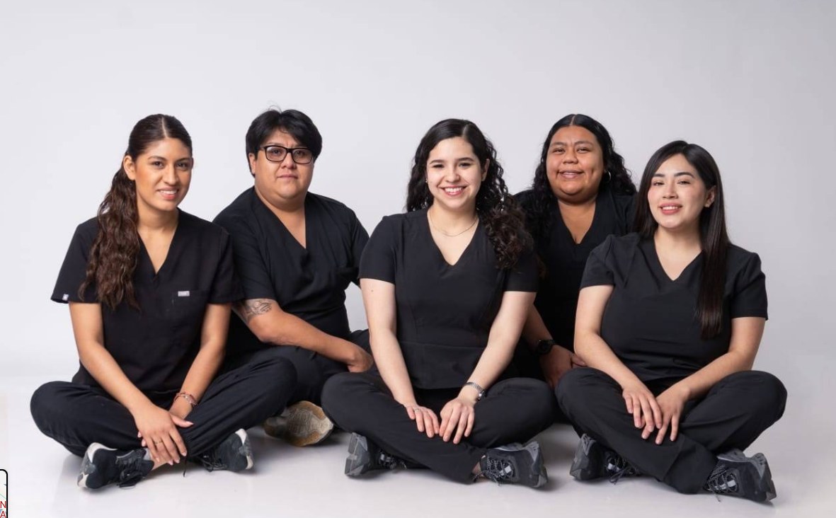 Equipo de Veterinaria Los Alazanes sentado en el suelo, con uniformes negros